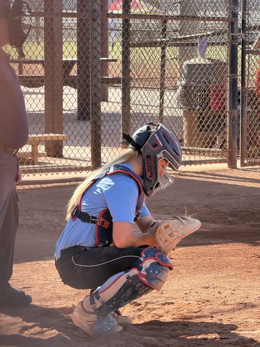 Softball catcher set behind the plate, DigiWrist receiver on the wrist