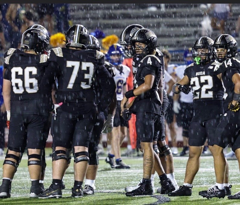 Hays linemen in the huddle under the lights